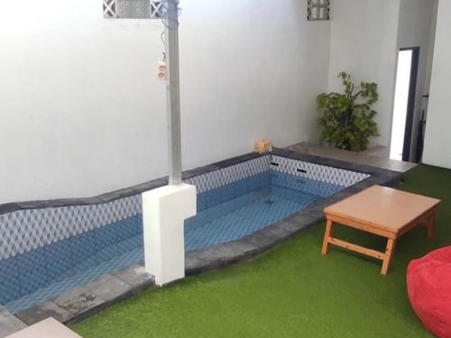 uma piscina numa sala de estar com uma mesa em Aliandra Villa by The Lavana em Yogyakarta