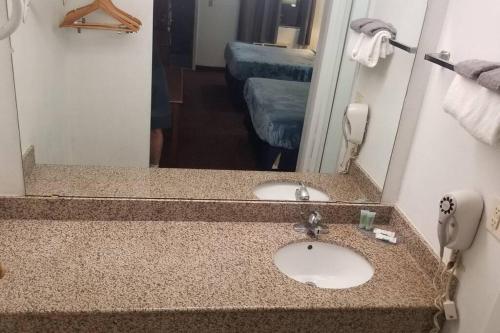 a bathroom with a sink and a mirror at OSU King Hotel Room 118 Booking in Stillwater