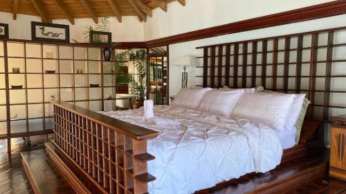 a bedroom with a large bed with a wooden headboard at Villa Olympia, St James Club - Luxury Open plan Villa, with Private Pool & 2 Kitchens in Bats Cave