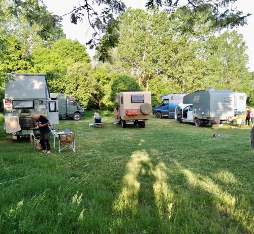 un hombre parado en un campo junto a un grupo de tiendas de campaña en Balabanağa Çiftliği Camping, 