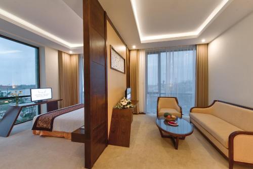 a hotel room with a bed and a couch at Muong Thanh Holiday Quang Binh Hotel in Dong Hoi