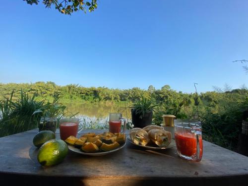 una mesa con dos platos de comida y bebida en Nui Tuong Village Stay, en Tân Phú