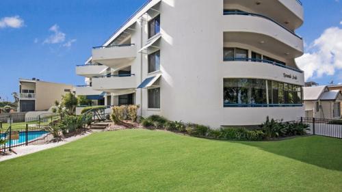 a large white building with a lawn in front of it at Views, Pool, Air Conditioning - Karoonda Sands Welsby Pde, Bongaree in Bongaree