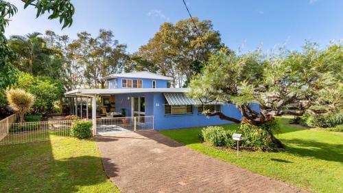 a blue house with a tree in the yard at Bribie Beach House, Waterfront directly across the road - Solander Esp, Banksia Beach in Old Bribie
