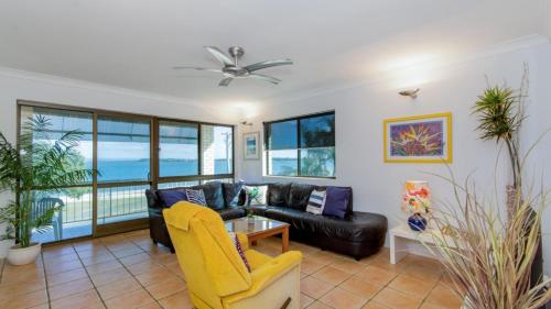 sala de estar con sofá y mesa en VIEWS VIEWS VIEWS! Front Top Floor Waterfront Unit - Chnook Apartments South Esp, Bongaree en Bongaree