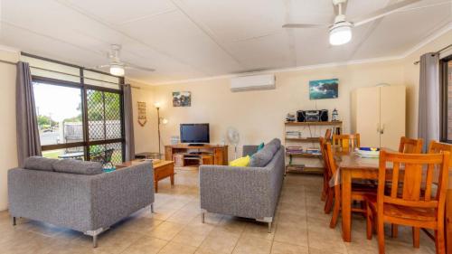 a living room with a table and chairs and a dining room at Pet friendly lowset home with room for a boat, Wattle Ave, Bongaree in Bellara