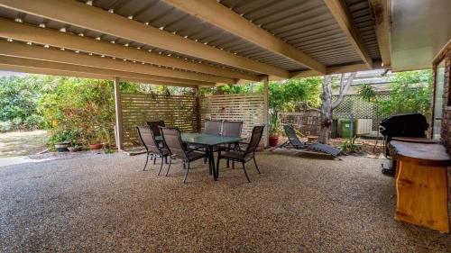 a patio with a table and chairs on it at Freshly revovated Dog Friendly House walking distance to Waterfront! in Bellara