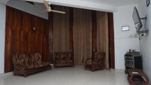 a living room with two chairs and a ceiling fan at V6 Holiday Bungalow in Badulla