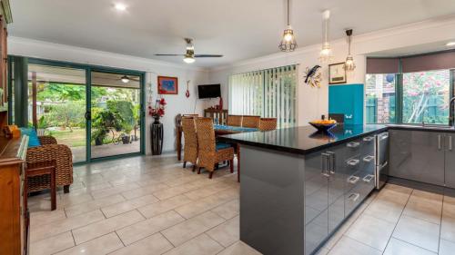 a kitchen and dining room with a table and chairs at Delightful Duplex on Rose Ct, Bongaree in Bongaree