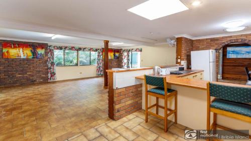 a kitchen with a counter and a bar in a room at Banksia Gem One Street Back From Waterfront in Banksia Beach