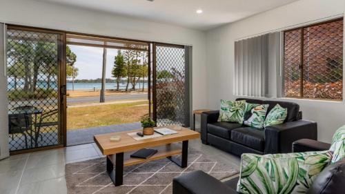 a living room with a couch and a table at Uninterruped Waterviews in Bongaree