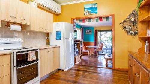 uma cozinha com electrodomésticos brancos e uma sala de jantar em Surfers Paradise At Woorim em Woorim