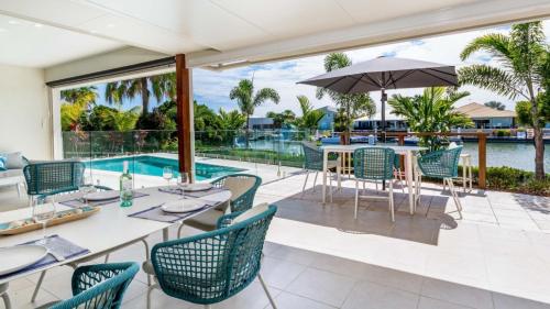 a patio with a table and chairs and a swimming pool at Paradise On The Promontory in Banksia Beach