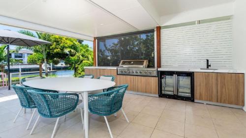 an outdoor kitchen with a white table and chairs at Paradise On The Promontory in Banksia Beach