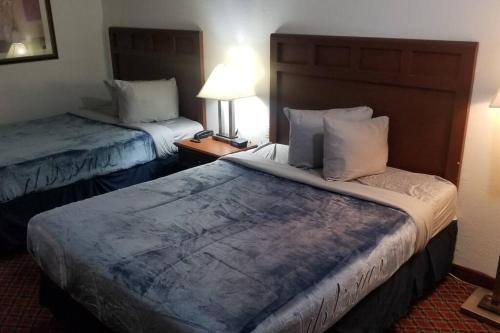ein Hotelzimmer mit 2 Betten und einer Lampe in der Unterkunft OSU 2 Queen Beds Hotel Room 125 Booking in Stillwater