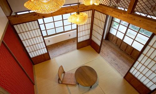una vista aérea de una habitación con mesa y sillas en ロフトが付いた沖縄古民家で寛ぎの時間を 懐かしくて新しい 海野24 en Nanjo