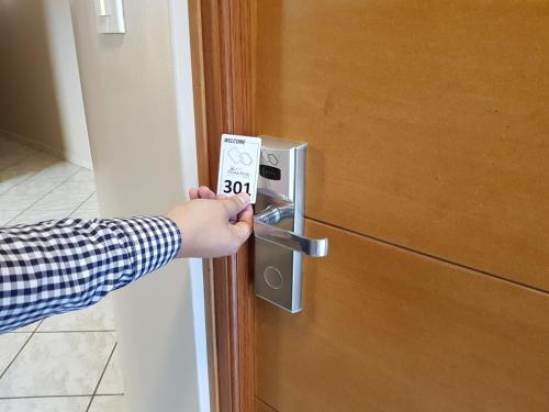a person is holding a thermometer in front of a door at Hotel Punta Rocas - Huacho in Huacho