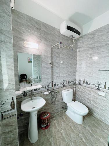 a bathroom with a white toilet and a sink at Tam Coc Guest House & Hostel in Ninh Binh