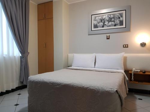 a bedroom with a bed with white pillows at Hotel Punta Rocas - Huacho in Huacho