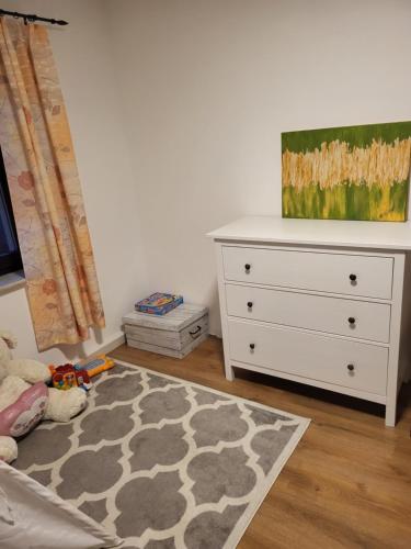 ein Schlafzimmer mit einer Kommode und einem Bett mit einem Teppich in der Unterkunft Haus Svetlana Ferienwohnung 