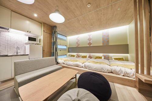 Zimmer mit 2 Betten und einem Tisch in der Unterkunft Hotel TORACO konohana in Osaka