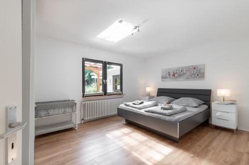 biała sypialnia z łóżkiem i oknem w obiekcie Großer Plöner See, Terrasse, Garten, Grill, Garage w mieście Plön