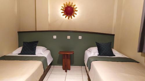 a room with two beds and a mirror on the wall at Hotel La Hasienda in Kupang