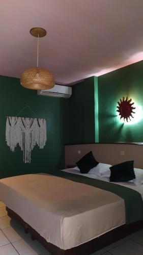 una camera con un letto con una parete verde di Hotel La Hasienda a Kupang