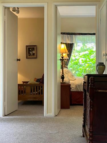 a bedroom with a bed and a window at English Gardens - Garden Retreat in Springbrook