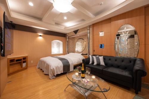 uma sala de estar com um sofá e uma cama em VALENTINE RESORT(大人専用） em Kasama