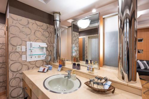 uma casa de banho com um lavatório e um espelho grande em VALENTINE RESORT(大人専用） em Kasama