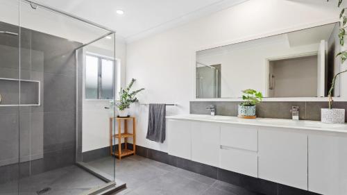 a bathroom with two sinks and a shower at 1 Ilya Street Currimundi QLD in Kawana Waters