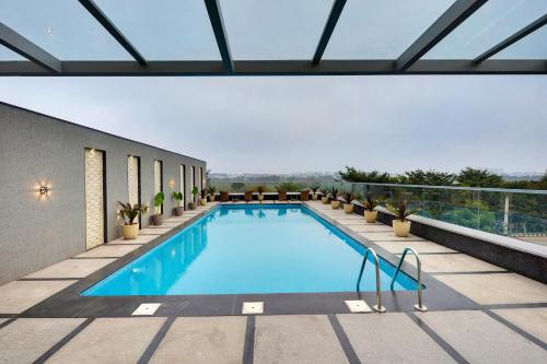 a swimming pool on top of a building at Clarion Hotel Bangalore in Bangalore