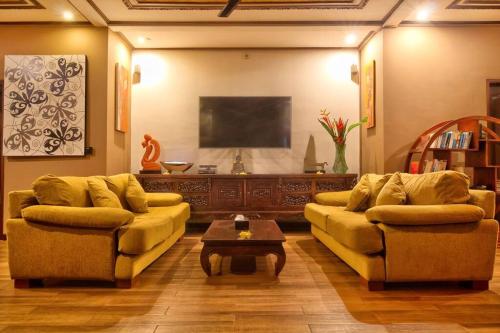 a living room with two couches and a flat screen tv at Uluwatu Huge 6 Bed Spa Villa - G8 views & Child Friendly in Jimbaran