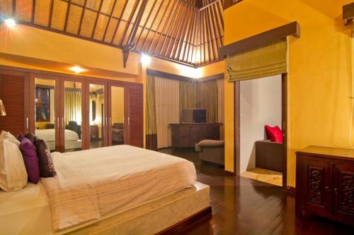 a bedroom with a large bed and a living room at Uluwatu Huge 6 Bed Spa Villa - G8 views & Child Friendly in Jimbaran