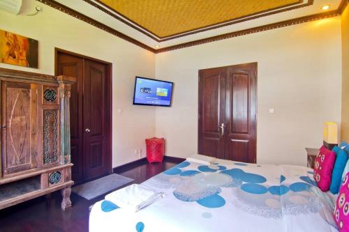 a bedroom with a large bed and a tv at Uluwatu Huge 6 Bed Spa Villa - G8 views & Child Friendly in Jimbaran