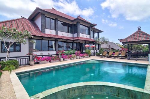 a house with a swimming pool in front of it at Uluwatu Huge 6 Bed Spa Villa - G8 views & Child Friendly in Jimbaran