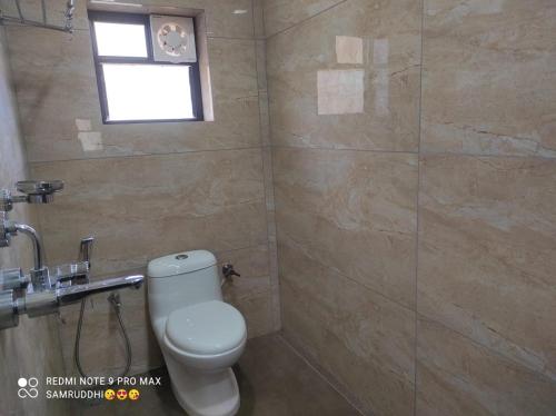 a bathroom with a toilet and a window at Hotel Calangute Central in Calangute