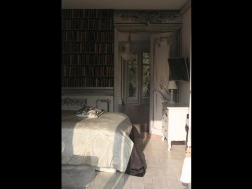 a bedroom with a bed and a room with books at Guesthouse Kathome in Bondues