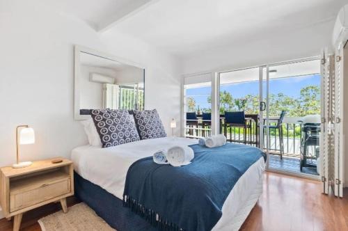 ein Schlafzimmer mit einem großen Bett und einem Balkon in der Unterkunft Ocean Views Central to everything , 2 bed, 2 minute walk to Beach in Noosa Heads