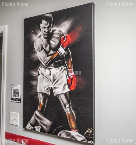 a painting of a boxing fighter on a wall at Luxury Sports Art Gallery - 15 mins to ATL Battery in Marietta