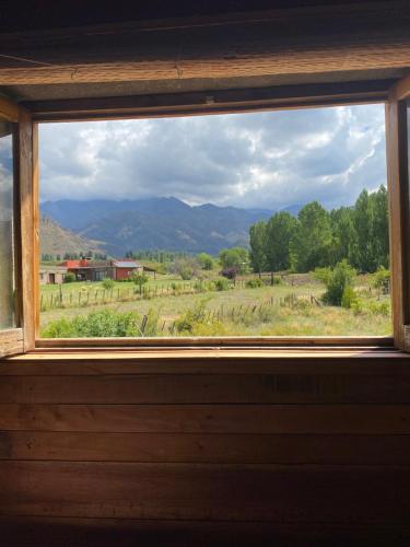 ventana con vistas al campo y a las montañas en Cabaña Lo de Mirtha en Tunuyán