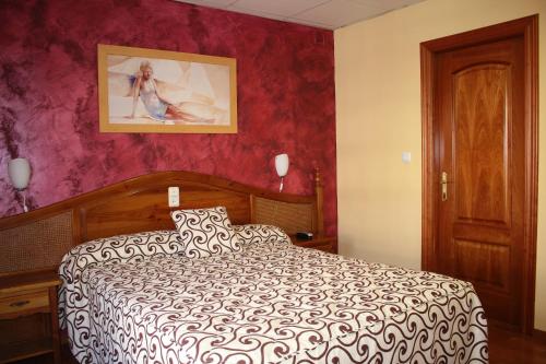 a bedroom with a bed and a painting on the wall at Hotel La Curva in Albolote