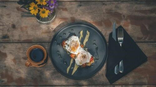 um prato de comida com ovos e batatas fritas numa mesa em Una Vida em Tulum