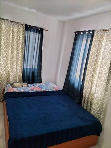 uma pequena cama num quarto com cortinas em House in Philippines em Liloan