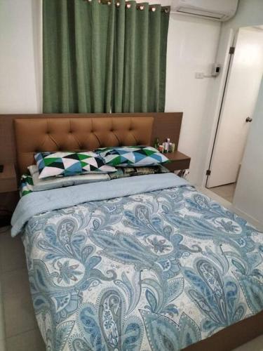 um quarto com uma cama com um edredão azul e branco em House in Philippines em Liloan