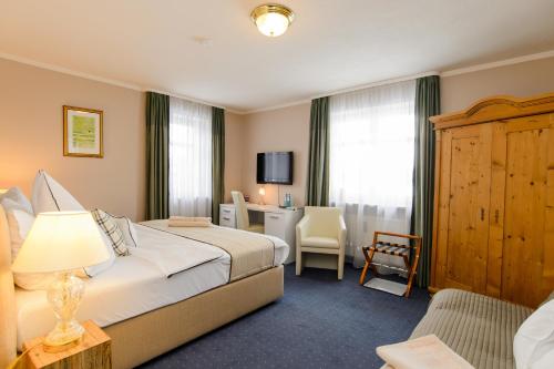 a hotel room with a bed and a desk at Landhaus Ambiente in Munich