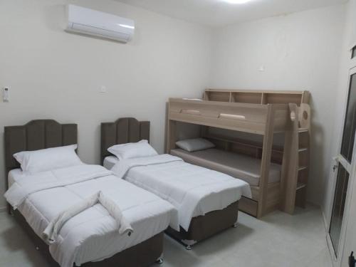 a room with two beds and a bunk bed at شقة فخمة وواسعة تسع عائلة كبيرة in Ajman 