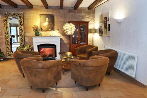 a living room with chairs and a table and a fireplace at Hotel Vorderburg in Schlitz