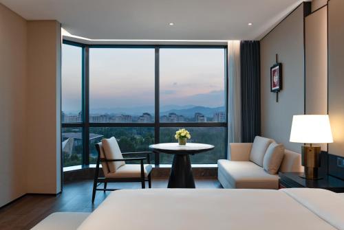 a hotel room with a bed and a table and chairs at Empark Grand Hotel Beijing in Beijing